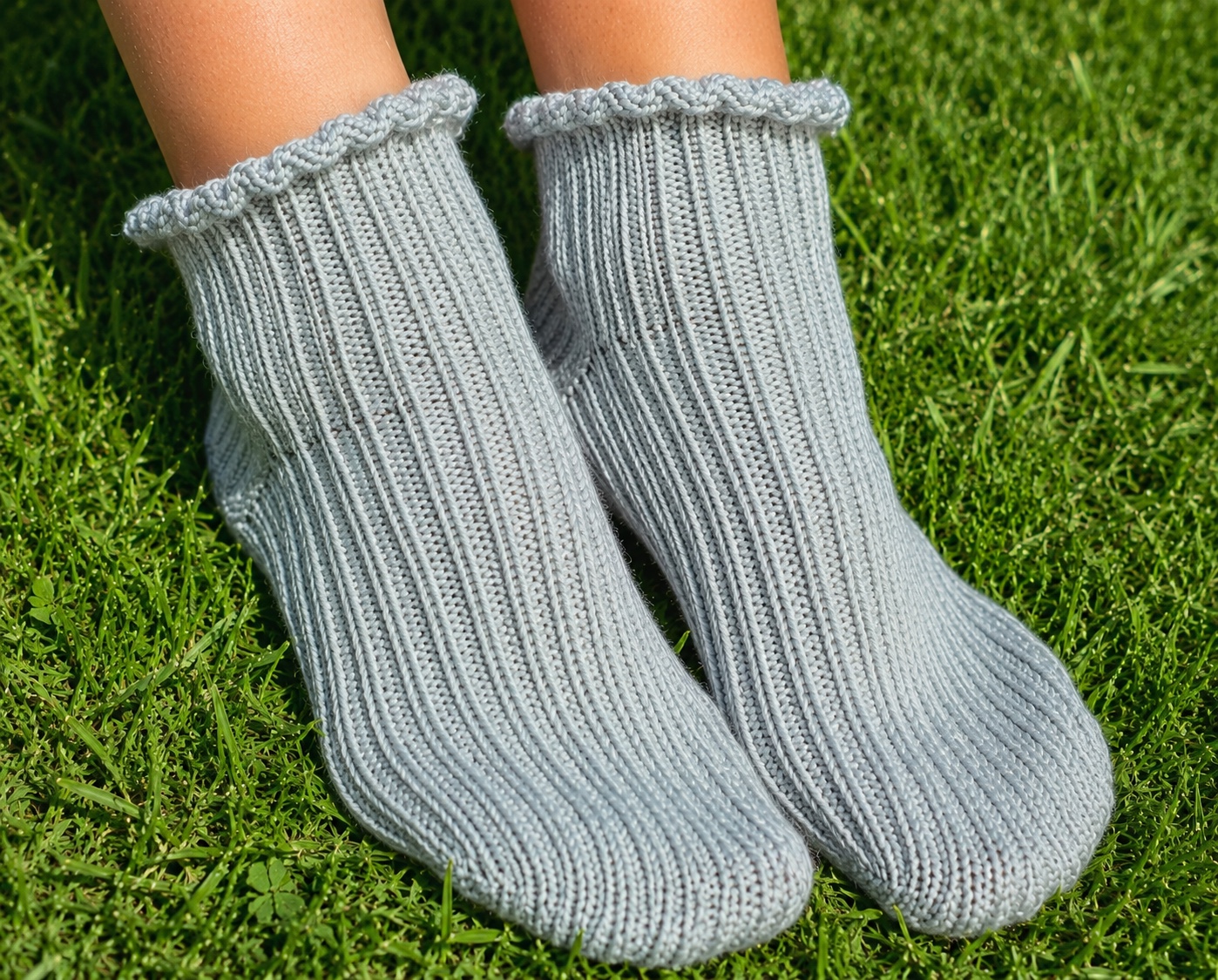 The Reagan hand-knit wool socks worn on feet resting on green grass